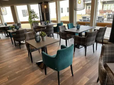 a restaurant with tables and chairs and windows at Oppdal Gjestetun Hotell in Oppdal