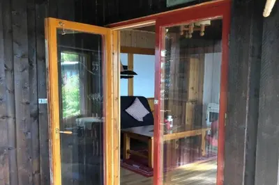 a room with two glass doors and a bench at Cottage - Sleeps 6 - Parking - Patio in Ytteroy