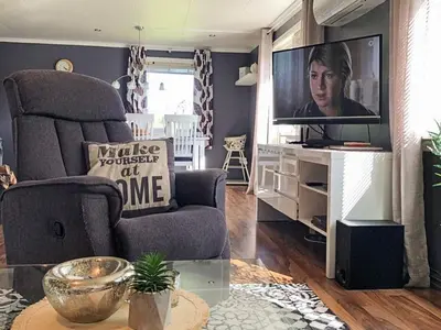 a living room with a chair and a television at 6 person holiday home in AVERØY in Stein