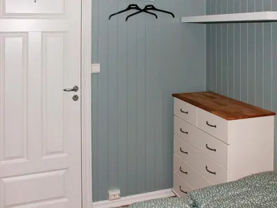 a bedroom with a bed and a dresser at 6 person holiday home in AVERØY in Stein