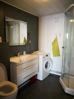 a bathroom with a washing machine and a washer at Yttervik gard in Steinkjer
