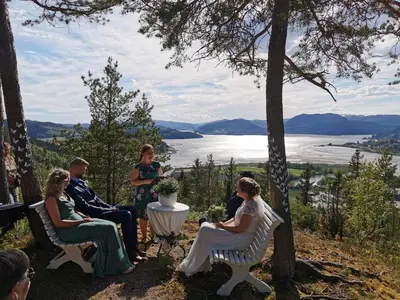 a group of people sitting around a table with a view at Yttervik gard in Steinkjer