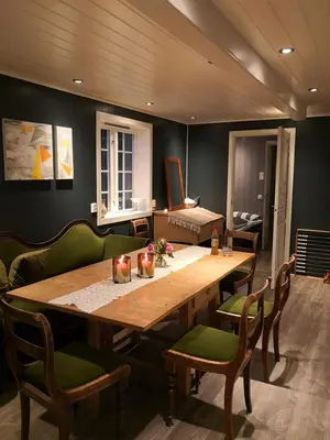 a wooden table in a room with green chairs at Yttervik gard in Steinkjer