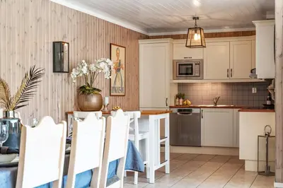 a kitchen with white cabinets and a table with white chairs at In the middle of Trysilfjellet - Welcome Center - Apartment with 3 bedrooms - By bike arena and ski lift in Trysil