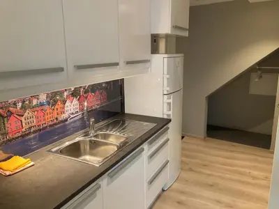 a kitchen with a sink and a refrigerator at Skansen Apartments in Bergen