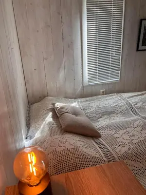 a bedroom with a bed with a candle on a table at Høgli på Yttervik gard in Fosnesstranden