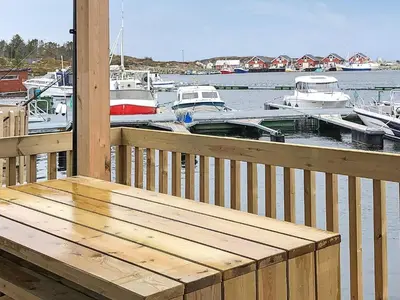a wooden deck with boats in the water at 6 person holiday home in Kverva in Dyrvik