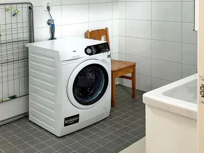 a washing machine in a bathroom next to a chair at 6 person holiday home in Kverva in Dyrvik