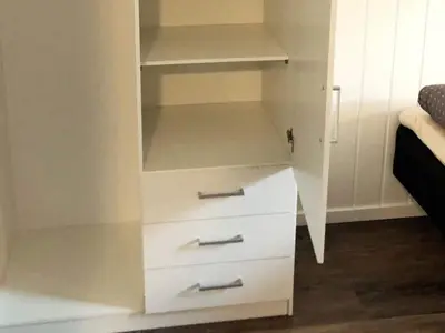 a white cabinet with drawers and shelves in a room at 6 person holiday home in Kverva in Dyrvik