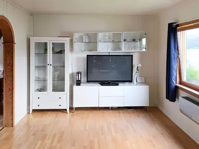 a living room with a television on a white cabinet at 9 person holiday home in KORTGARDEN in Skalle