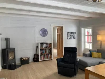 a living room with a couch and a chair and a clock at Comfortable house in quiet area in Luster