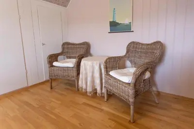 two wicker chairs and a table in a room at Raaehuset in Lavik