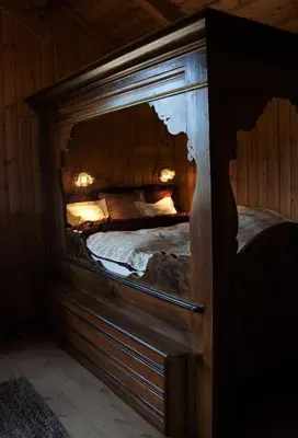 a wooden bed in a room with a wooden wall at Bolkesjø Gaard in Notodden