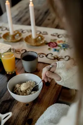 a person is eating food in a bowl on a table at Vollsnes Gjestehus in Stryn