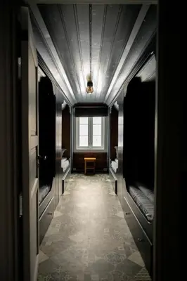 a hallway with bunk beds in a room with a window at Vollsnes Gjestehus in Stryn