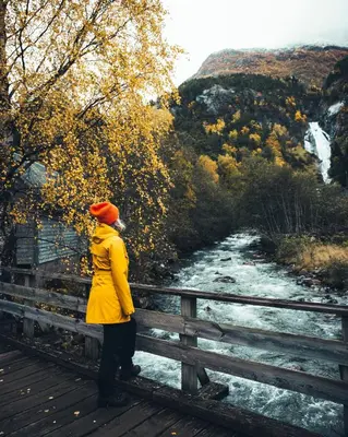 a woman standing on a bridge looking at a river at Vollsnes Gjestehus in Stryn