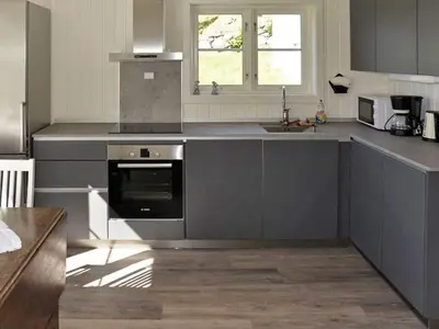 a kitchen with gray cabinets and a sink and a stove at 10 person holiday home in Stordal in Stordal