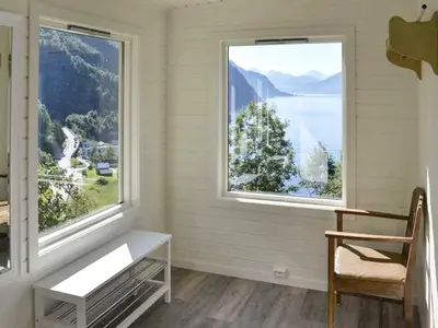 a room with two windows with a chair and a table at 10 person holiday home in Stordal in Stordal