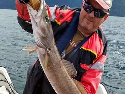 a man holding a fish in a boat at 10 person holiday home in Stordal in Stordal