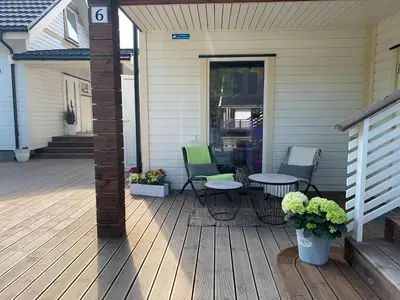 a porch with chairs and a table on a house at Flatanger Turkish Bath apartment in Lauvsnes