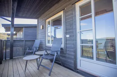 a porch with two chairs and a table and a window at Hodlekve Panorama 5 - amazing view in Sogndal