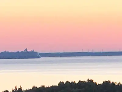 an island in the middle of the water at sunset at 6 person holiday home in Aure-By Traum in Aure