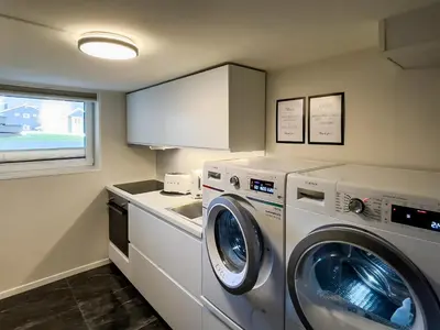 a laundry room with a washing machine and a sink at ÅNDALSNES UNDERGROUND flat in Åndalsnes