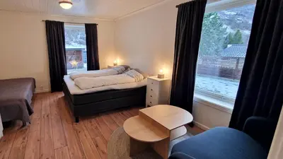 a bedroom with a bed and a couch and a window at Otnes Fjordside - Large 80m2 860sqft in Aurland