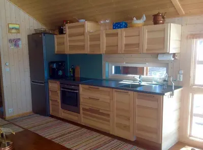 a kitchen with wooden cabinets and a sink at Skarehaug - koselig hytte med 3 soverom in Eggedal