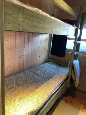an empty bunk bed in a wooden cabin at Skarehaug - koselig hytte med 3 soverom in Eggedal