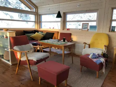 a living room with a couch and a table and chairs at Skarehaug - koselig hytte med 3 soverom in Eggedal
