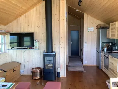a kitchen with a stove in the middle of a room at Skarehaug - koselig hytte med 3 soverom in Eggedal
