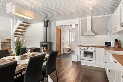 a kitchen and dining room with a table and a fireplace at Cabin in Trysil with seaview to lake in Trysil