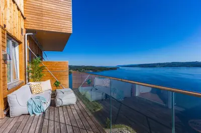 a balcony with a view of a body of water at Mjøssuite with lovely view in Ringsaker