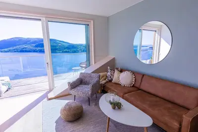 a living room with a couch and a large window at Mjøssuite with lovely view in Ringsaker