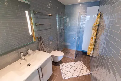a bathroom with a sink and a toilet and a shower at Mjøssuite with lovely view in Ringsaker