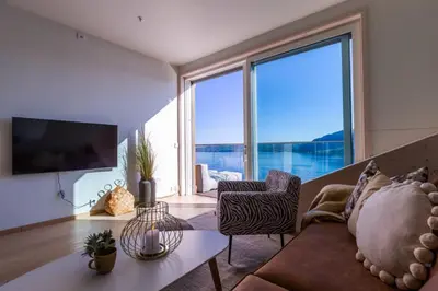 a living room with a couch and a large window at Mjøssuite with lovely view in Ringsaker