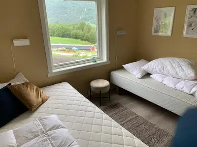 a bedroom with two beds and a window at Dispen feriehus in Stryn