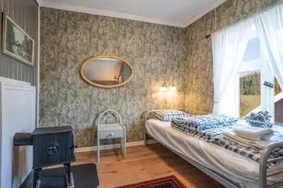 a bedroom with two beds and a mirror on the wall at Eika Cottage: Cozy, rural, spacious and well-equiped in Åmot