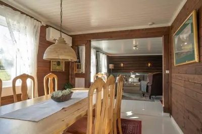 a dining room with a wooden table and chairs at Eika Cottage: Cozy, rural, spacious and well-equiped in Åmot