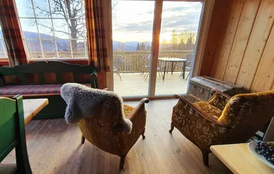 a living room with two chairs and a large window at Hjartdal Fjellstoge & Storhytte in Hjartdal