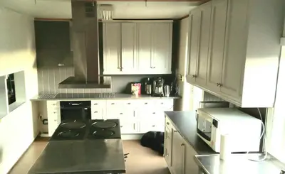 a kitchen with white cabinets and a stove top oven at Hjartdal Fjellstoge & Storhytte in Hjartdal