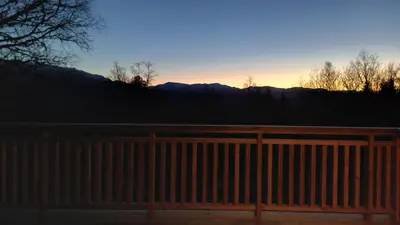 a wooden fence with the sunset in the background at Hjartdal Fjellstoge & Storhytte in Hjartdal
