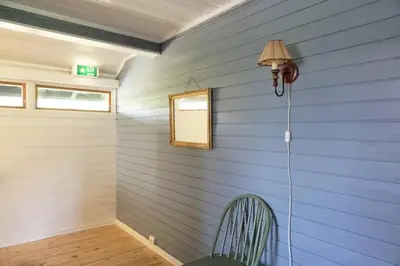 a blue room with a chair and a lamp at Hjartdal Fjellstoge & Storhytte in Hjartdal