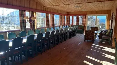 a large room with chairs and tables and windows at Hjartdal Fjellstoge & Storhytte in Hjartdal