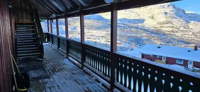 a balcony with a view of a snow covered mountain at Røisheim in Tyinkrysset