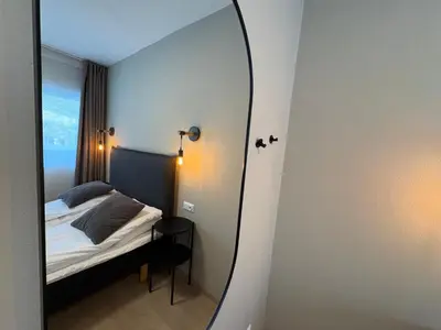 a mirror in a small room with a bed at Hotel Videseter in Stryn