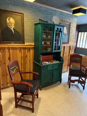 a green cabinet in a room with two chairs at Hotel Videseter in Stryn