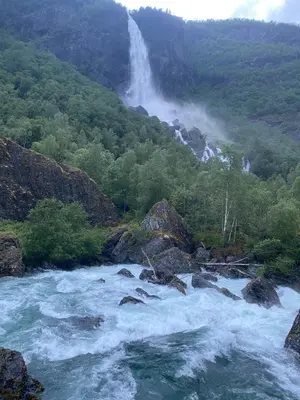 a waterfall in the middle of a river at Indreli feriehus in Flåm