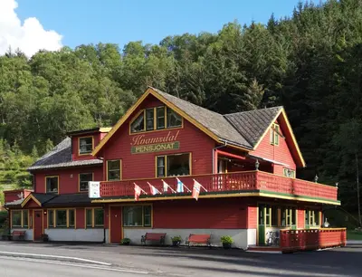 a red inn with flags on the front of it at Kvamsdal Pensjonat 2 in Eidfjord